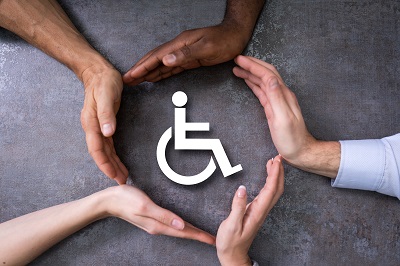 hands around a wheelchair symbol